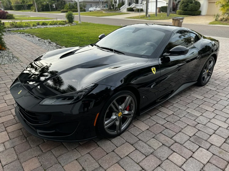 Black Ferrari detailed in a Tampa driveway by The White Glove Detailer